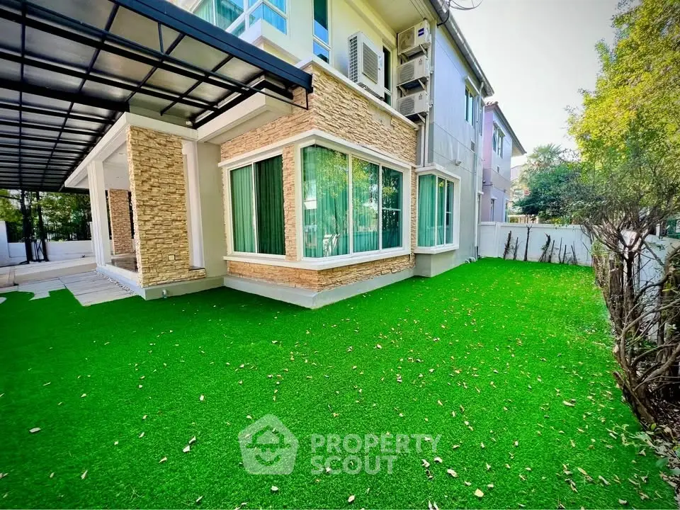 Charming suburban home with lush green lawn and modern stone facade