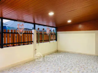 Spacious covered patio with wooden ceiling and decorative wall accents