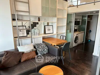 Modern loft apartment with stylish living area and compact kitchen featuring washing machine.