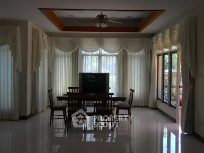 Spacious living room with elegant curtains and wooden dining set