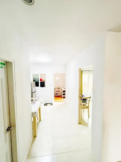 Bright hallway leading to a modern kitchen with dining area.