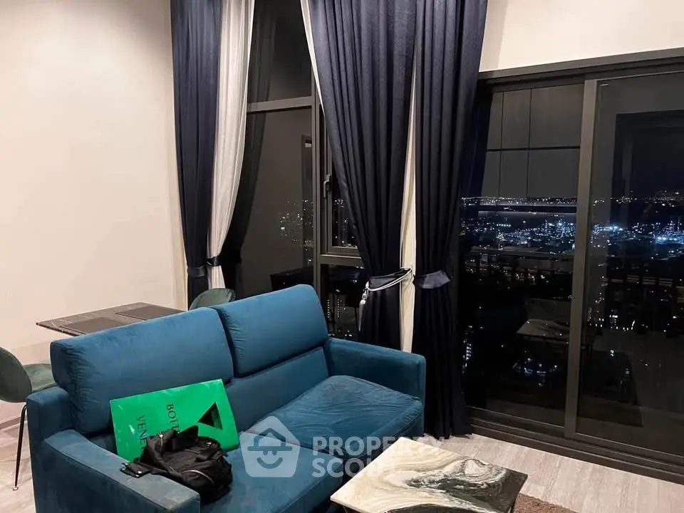 Luxurious living room with stunning city view, elegant blue sofa, and floor-to-ceiling windows.