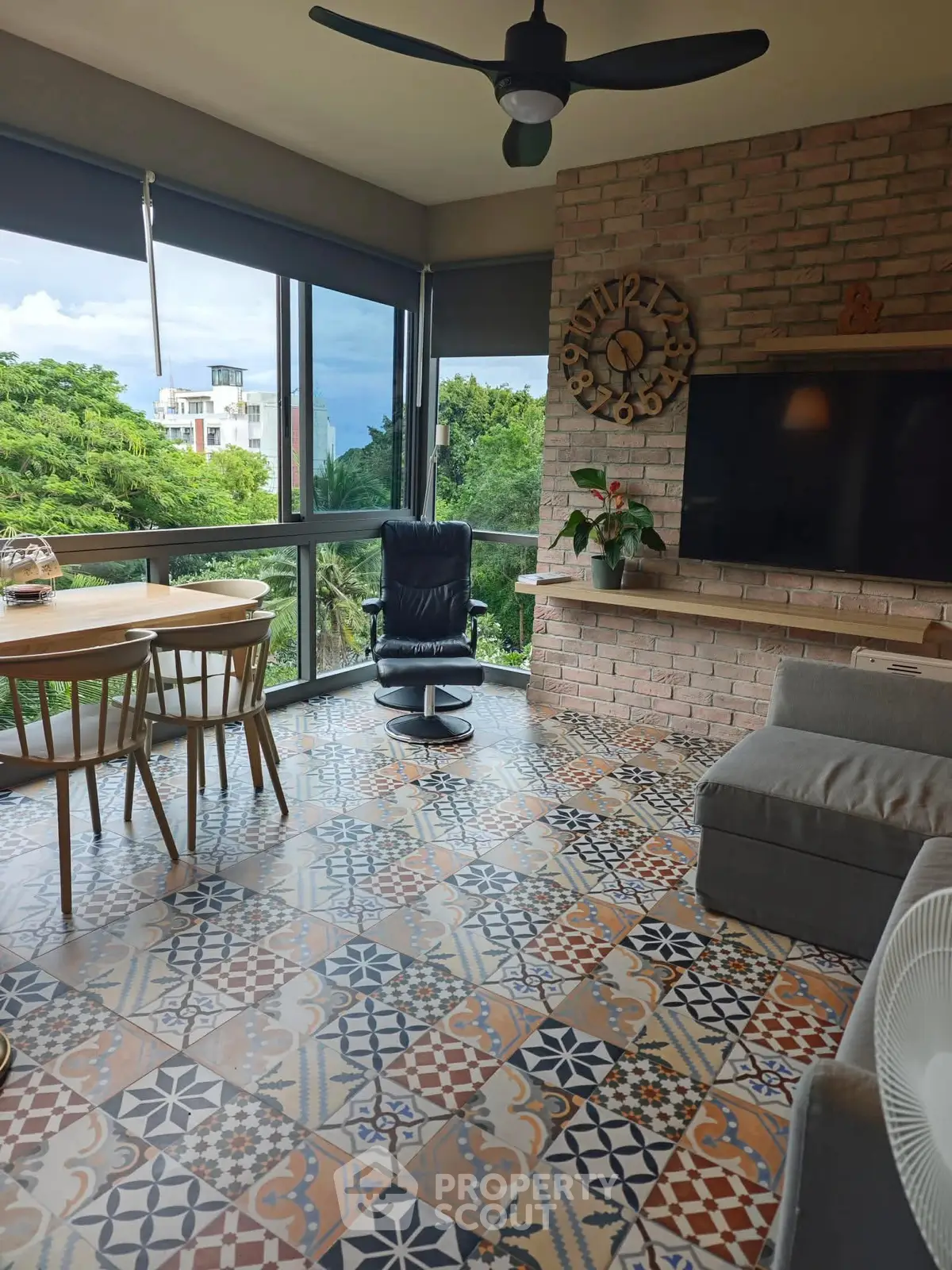 Charming living room with patterned tile floor and large windows offering lush green views.