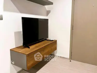 Modern minimalist living room with wall-mounted TV and sleek wooden cabinet.