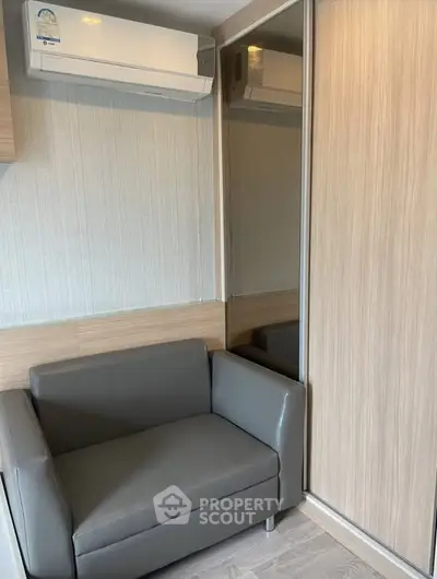 Modern compact living room with sleek sofa and mirrored wardrobe