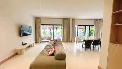 Spacious modern living room with elegant decor and large windows offering garden views.