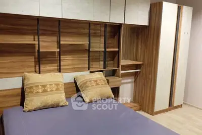 Modern bedroom with stylish wooden furniture and cozy bedding