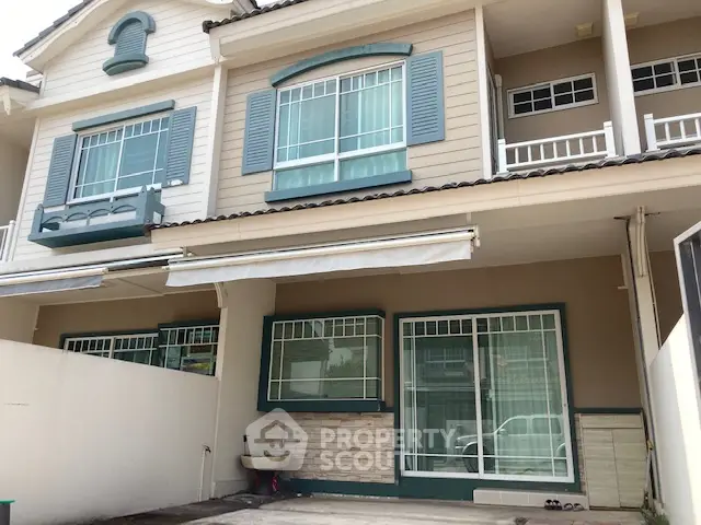 Charming townhouse exterior with large windows and shutters in a serene neighborhood.