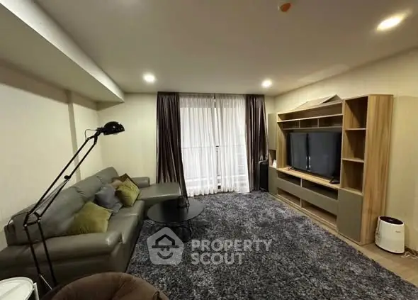Spacious living room with modern furniture and entertainment center, perfect for relaxation.