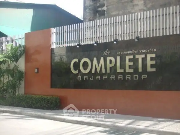 Modern entrance of The Complete Rajaprarop with sleek design and lush greenery.
