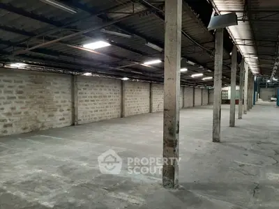 Spacious industrial warehouse with high ceilings and ample open floor space.