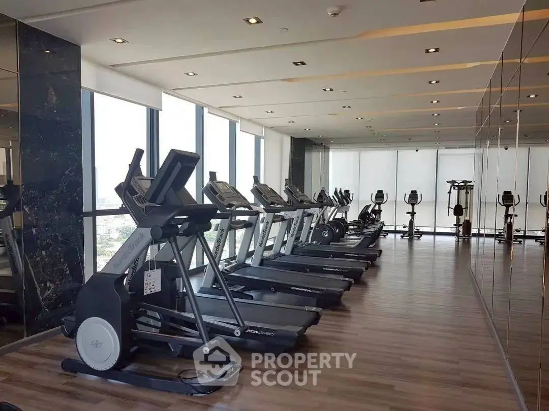 Modern gym with treadmills and large windows offering a panoramic view.