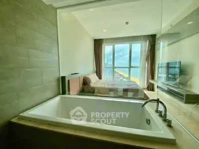 Luxurious bedroom with bathtub and stunning city view through large windows.