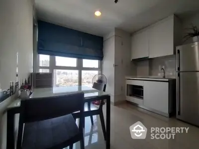 Modern kitchen with dining area and large window offering city views