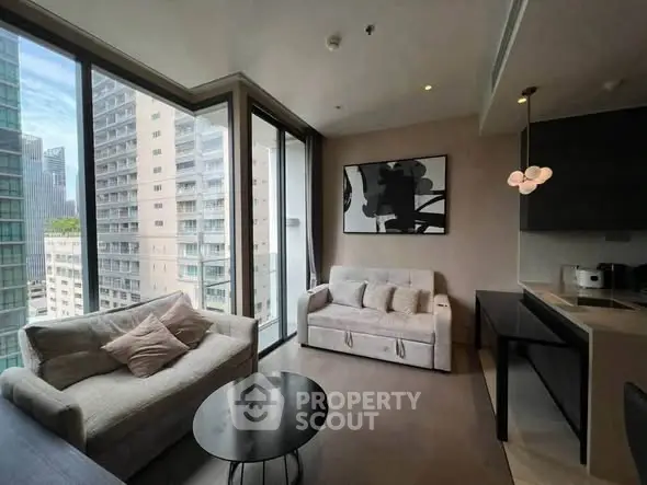 Modern living room with large windows and city view, featuring cozy sofas and stylish decor.