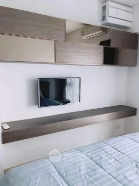 Modern bedroom with sleek wall-mounted TV and stylish storage solutions.