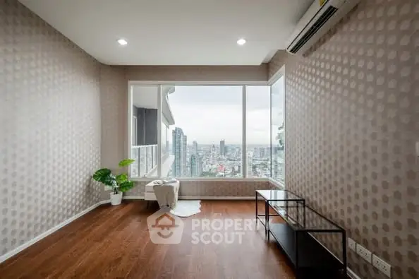 Spacious room with large windows offering stunning city views and modern decor.