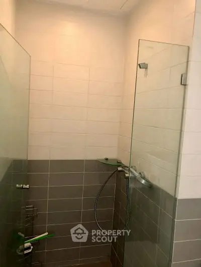 Modern bathroom with glass shower enclosure and sleek tile design.