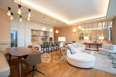 Luxurious open-plan living room with modern kitchen and elegant furnishings, featuring stylish lighting and wooden flooring.