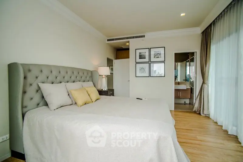 Luxurious bedroom with elegant decor and large windows offering natural light.