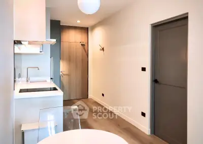 Modern minimalist kitchen with sleek design and neutral tones, featuring a compact layout and stylish fixtures.
