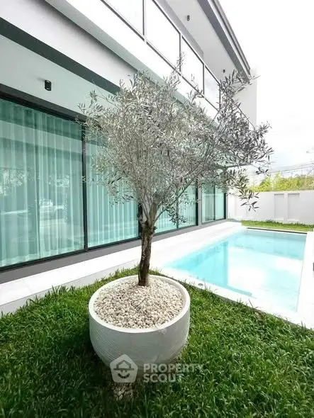 Modern home exterior with pool and lush garden, perfect for relaxation and entertainment.