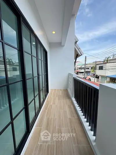 Spacious balcony with modern railing and city view, perfect for relaxation.