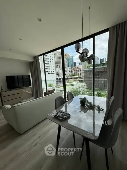 Modern living room with city view, stylish furniture, and large windows.