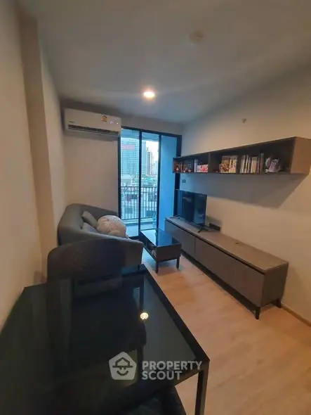 Modern living room with city view, featuring sleek furniture and a cozy atmosphere.