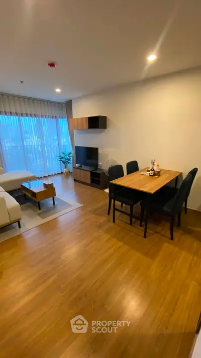 Spacious modern living room with dining area and large windows in a stylish apartment.