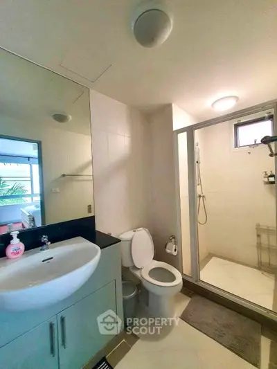 Modern bathroom with glass shower and sleek fixtures in a contemporary home.