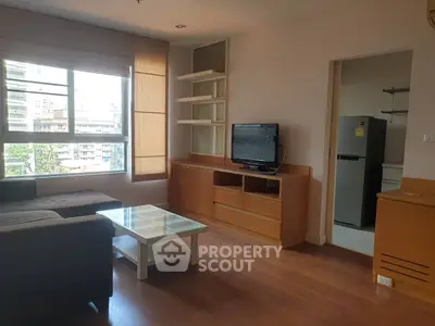 Spacious living room with modern furniture and large window offering city views.