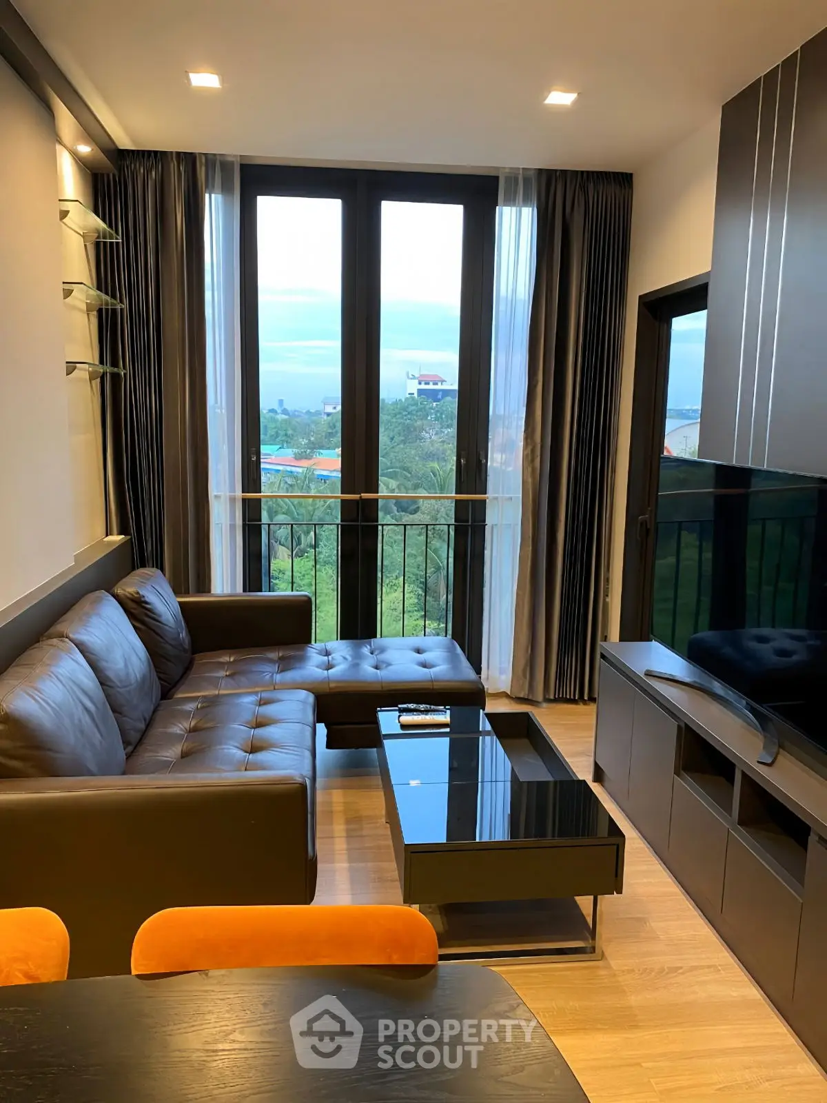 Modern living room with large windows and stylish furniture, offering a scenic view.