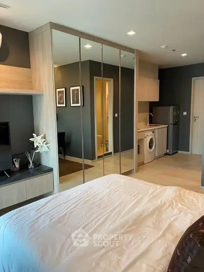 Modern studio apartment with mirrored wardrobe and compact kitchen
