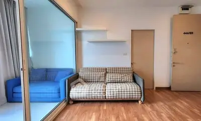 Cozy living room with checkered sofa and wooden flooring, ideal for modern urban living.