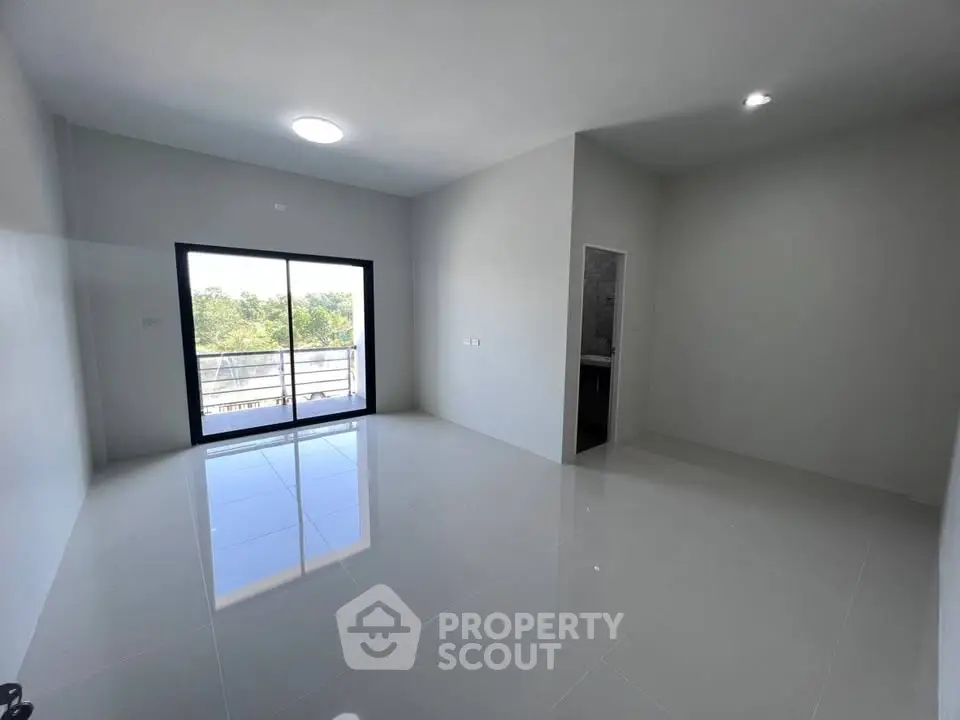 Spacious modern living room with large windows and balcony access