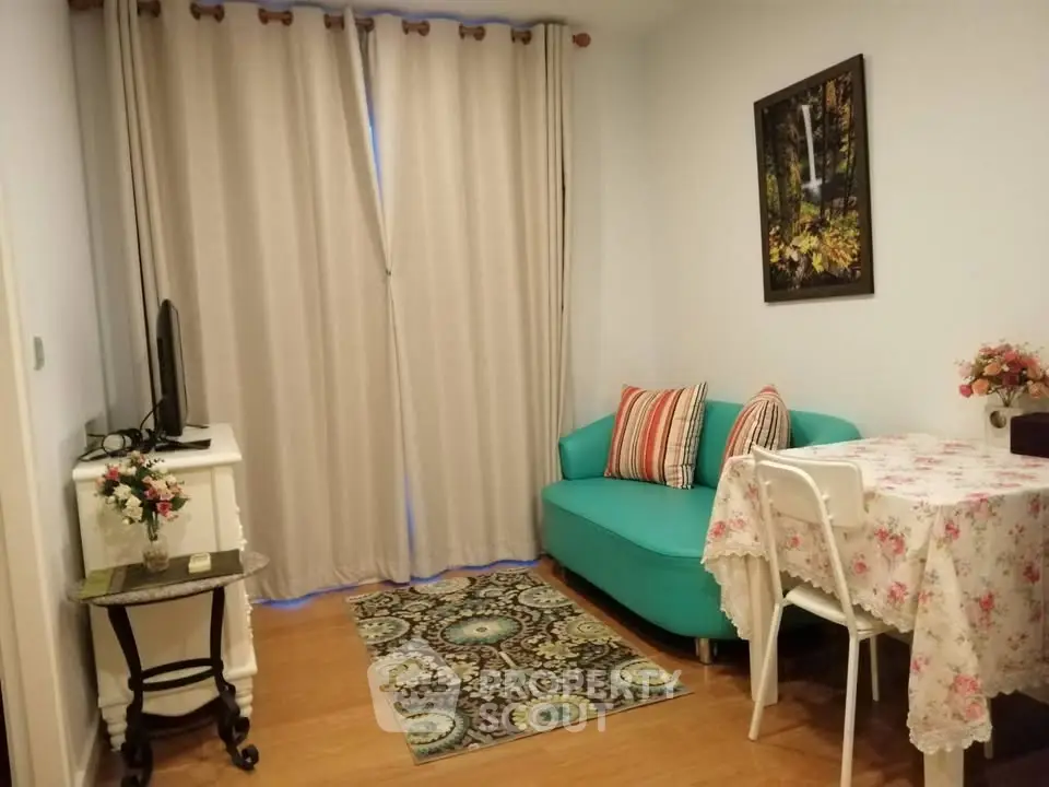Charming living room with teal sofa, floral decor, and cozy ambiance.