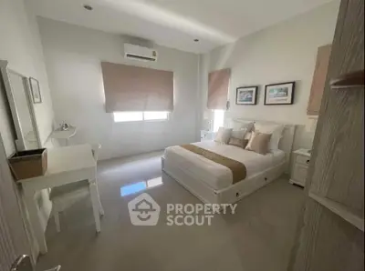 Spacious and bright bedroom with modern decor and ample natural light.