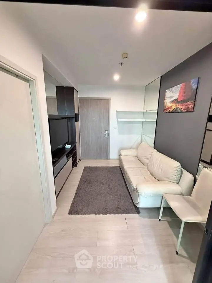 Modern living room with sleek design and cozy white sofa in a compact apartment.