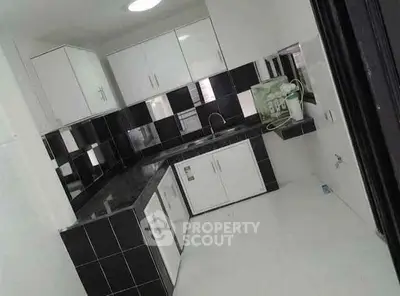 Modern kitchen with black and white cabinetry and sleek countertops