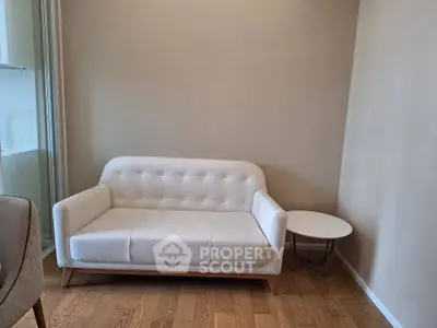 Cozy living room with elegant white sofa and wooden flooring, perfect for modern living.