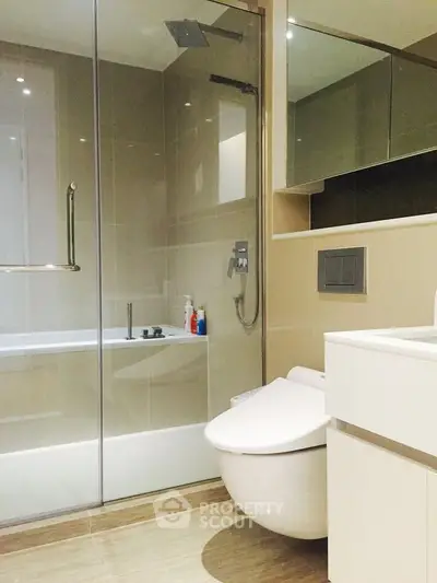 Modern bathroom with sleek fixtures and glass shower enclosure in a luxury apartment.
