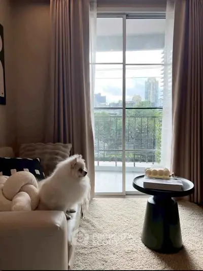 Cozy living room with a pet-friendly ambiance and balcony view, perfect for relaxation.