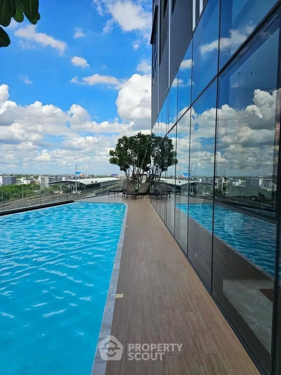 Stunning rooftop pool with panoramic city views and modern glass facade.