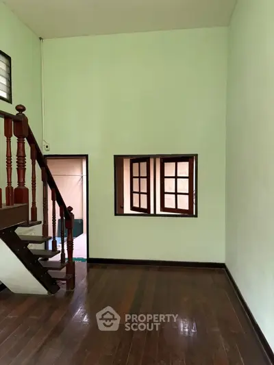 Charming interior with wooden staircase and bright walls, perfect for cozy living.