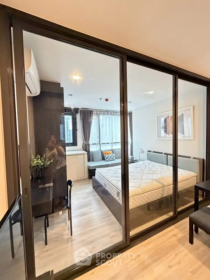 Modern bedroom with glass partition and stylish decor in urban apartment