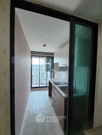 Modern kitchen with sleek cabinetry and large window offering city view