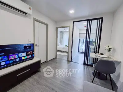 Modern living room with sleek TV setup and view into a cozy bedroom, featuring stylish decor and efficient use of space.