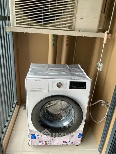 Compact laundry area with washing machine and air conditioning unit on balcony.