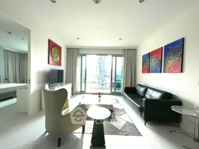Spacious modern living room with stylish decor and large windows offering city views.